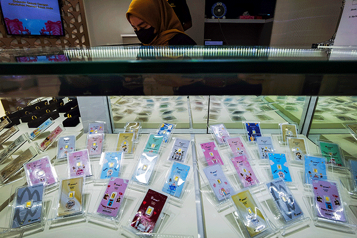 Pedagang menunjukan produk emas Batangan gift series di Toko Hartadinata Abadi, Cikini Gold Center, Jakarta, Senin (14/3/2022).