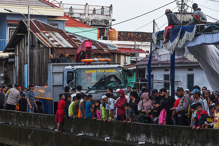 Petugas mengevakuasi mobil jenis Daihatsu Xenia bernomor polisi BG 1162 RR warna silver dari dalam sungai Jembatan Gledek, Palembang, Minggu (13/3/2022).
