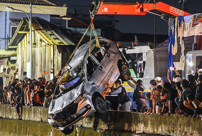 Petugas mengevakuasi mobil jenis Daihatsu Xenia bernomor polisi BG 1162 RR warna silver dari dalam sungai Jembatan Gledek, Palembang, Minggu (13/3/2022).