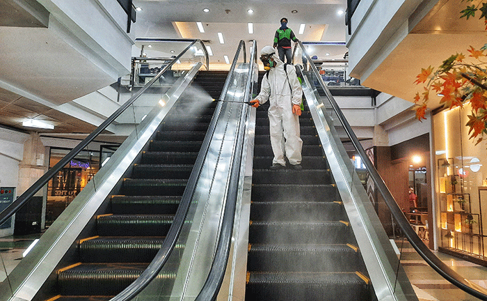 Petugas melakukan penyemprotan disinfektan di area Mall Ratu Indah, Makassar, Minggu (13/3/2022).