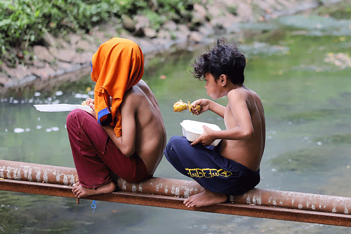 Sejumlah anak menikmati makanan dan bermain di Kali Gresik, Menteng, Jakarta, Senin (14/3/2022).