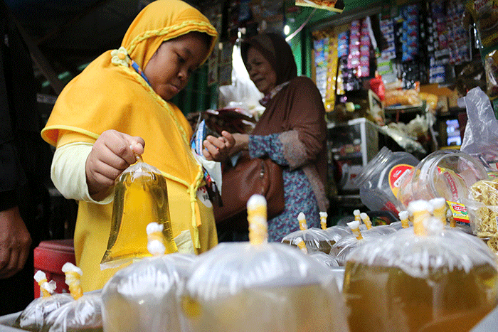 Pedagang melayani pembeli minyak curah dan minyak kemasan di kawasan pasar Kemayoran Jakarta, Rabu (16/3/2022).