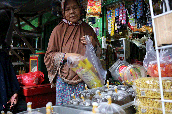 Pedagang melayani pembeli minyak curah dan minyak kemasan di kawasan pasar Kemayoran Jakarta, Rabu (16/3/2022).