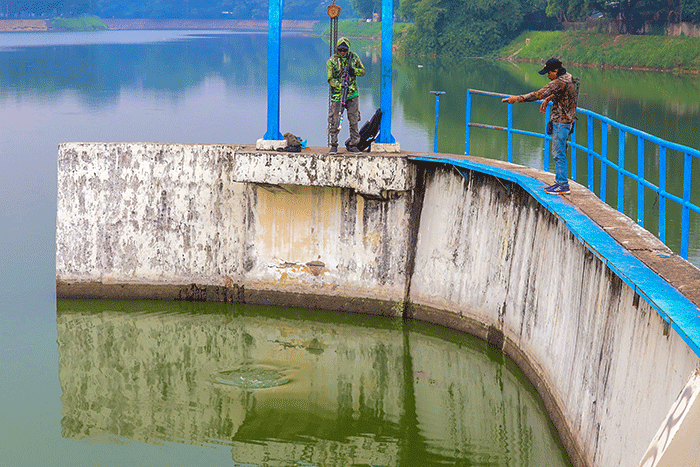 Warga saat memancing ikan dengan cara inovatif menggunakan modifikasi senapan angin di Situ Gintung, Tangerang Selatan, Kamis (17/3/2022).