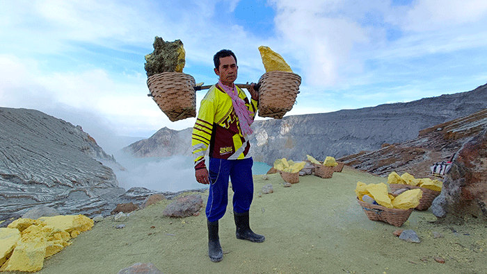 Penambang memikul belerang di Kawah Ijen, Banyuwangi, Jawa Timur, Jumat (18/3/2022).