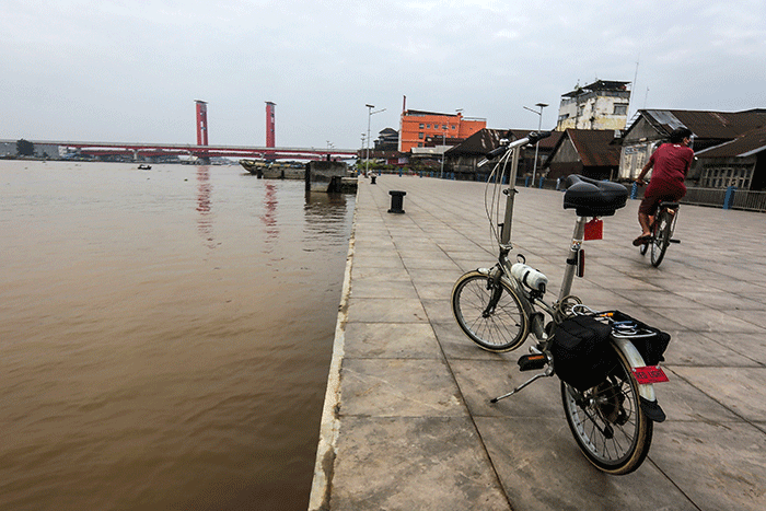 Warga bersepeda menikmati kota Palembang, Minggu (20/3/2022).