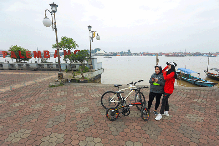 Warga bersepeda menikmati kota Palembang, Minggu (20/3/2022).