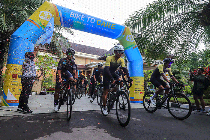 Peserta Bike To Care 2022 #BaliLoop 500 Km menunjukkan medali usai melintasi garis finish etape dua di Sol Benoa, Badung, Bali, Minggu (20/3/2022).