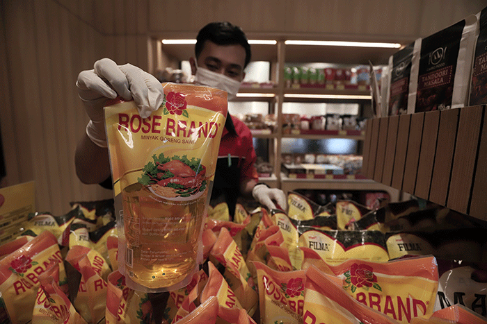Karyawan toko menata minyak goreng di Jakarta, Kamis (24/3/2022).