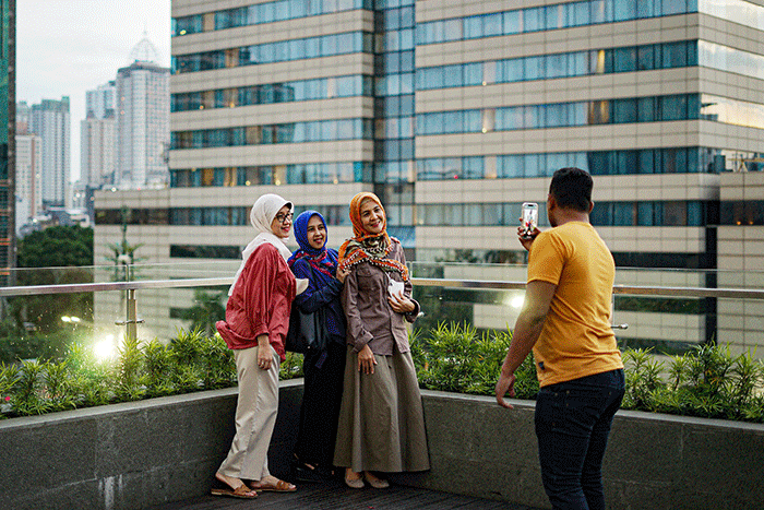 Pengunjung saat berswafoto dengan latar belakang gedung bertingkat di Skydeck Mal Sarinah, Jakarta Pusat, Rabu (23/3/2022).
