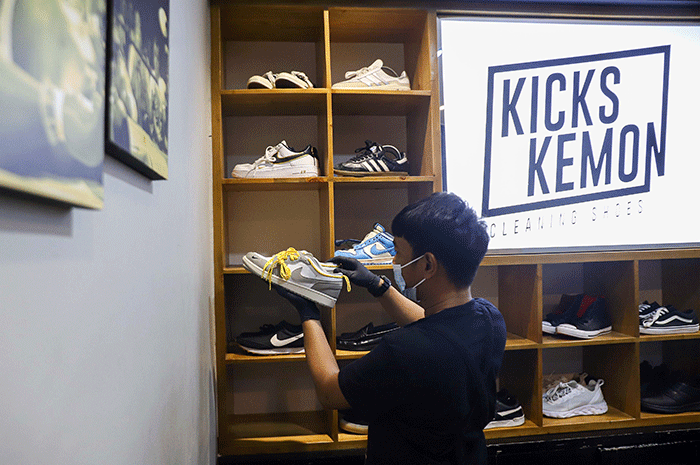 Pekerja membersihkan sepatu pelanggan di Cleaning Shoes Kicks Kemon, Haji Nawi, Jakarta Selatan, Sabtu (26/3/2022).