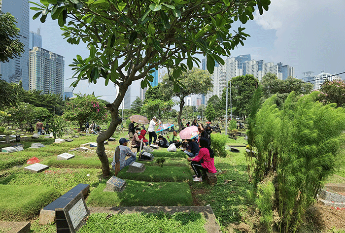 Peziarah memanjatkan doa di makam keluarga dan kerabat di Taman Pemakaman Umum (TPU) Karet Bivak, Jakarta, Minggu, (27/3/2022).