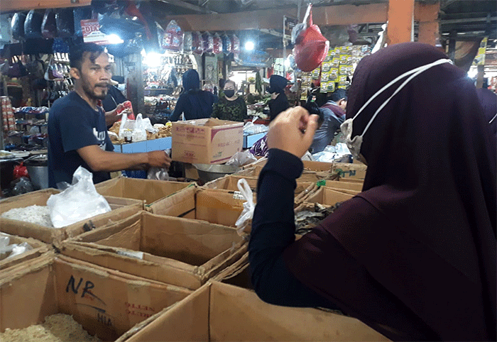 Pedagang melayani pembeli di Pasar Kecapi, Kota Bekasi, Jawa Barat, Selasa (29/3/2022).