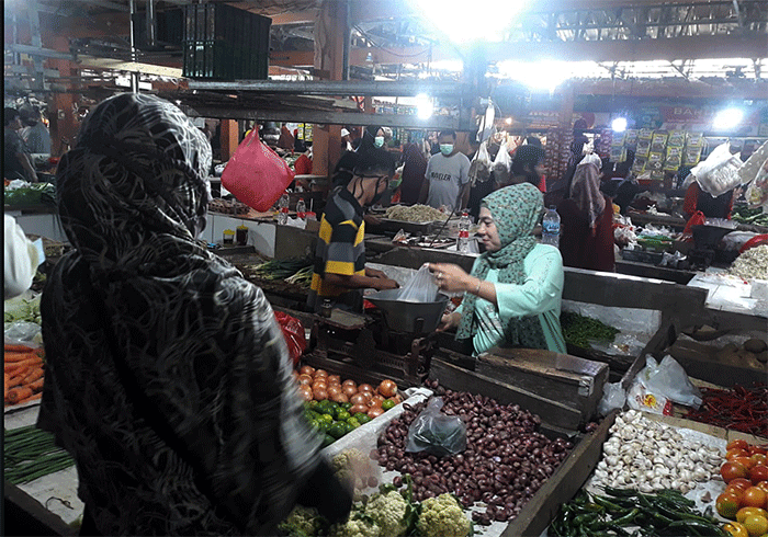 Pedagang melayani pembeli di Pasar Kecapi, Kota Bekasi, Jawa Barat, Selasa (29/3/2022).