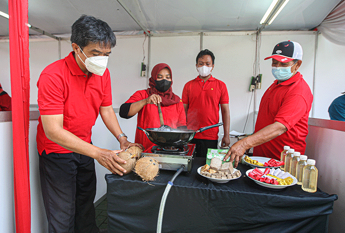 Kader Partai Demokrasi Indonesia Perjuangan (PDIP) menunjukan hasil olahan minyak kelapa saat acara demo masak tanpa minyak goreng.