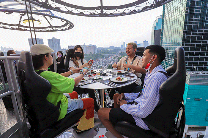 Pengunjung menyantap hidangan di Lounge In The Sky, Jakarta, Selasa (29/3/2022).