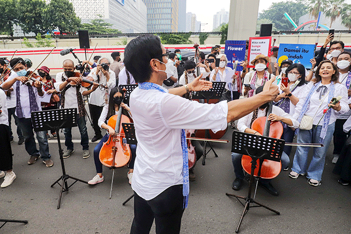 Komposer Addie MS menjadi konduktor orkestra saat menggelar seruan aksi damai di Depan Kedutaan Besar Rusia di Kuningan, Jakarta Selatan, Rabu (30/2/2022).