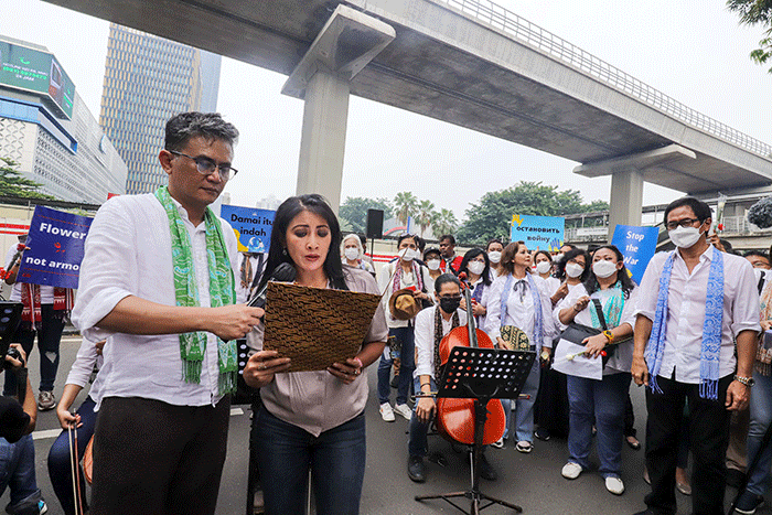 Komposer Addie MS menjadi konduktor orkestra saat menggelar seruan aksi damai di Depan Kedutaan Besar Rusia di Kuningan, Jakarta Selatan, Rabu (30/2/2022).