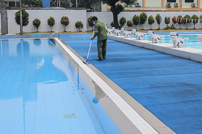 Petugas membersihkan dan merawat area kolam renang di Gelanggang Remaja Jakarta Selatan (GRJS) Bulungan, Kebayoran Baru, Jakarta, Kamis (31/3/2022).