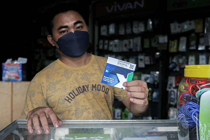 Penjual menunjukkan kartu perdana di konter pulsa kawasan Jakarta Timur, Jumat (1/4/2022).