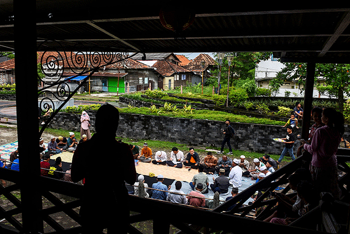 Warga Muslim Kampung Kapitan melaksanakan acara sedekah Kampung Kapitan di depan rumah Kapitan pinggiran Sungai Musi.