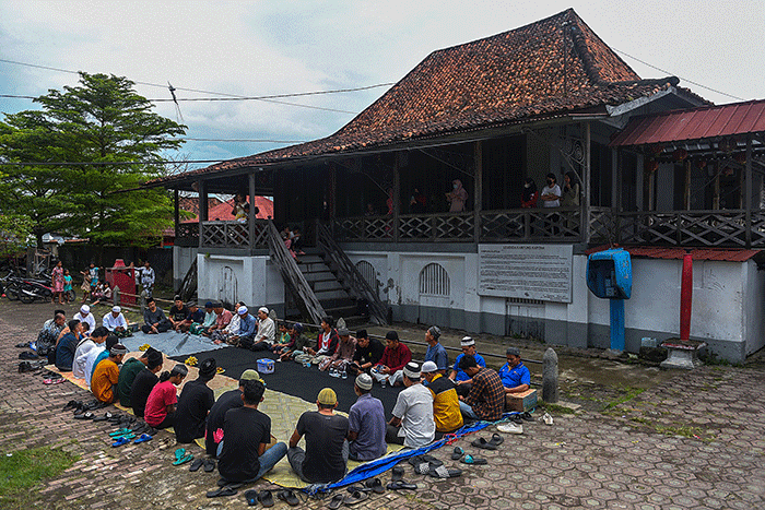 Warga Muslim Kampung Kapitan melaksanakan acara sedekah Kampung Kapitan di depan rumah Kapitan pinggiran Sungai Musi.