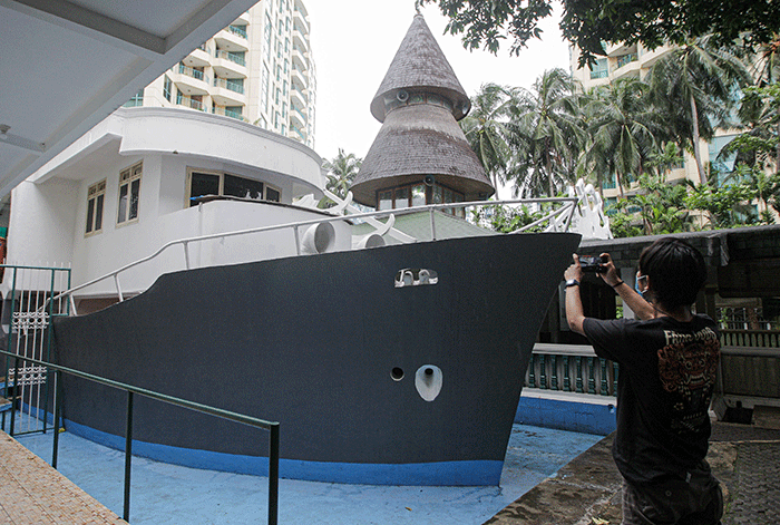 Pengunjung berswafoto berlatar belakang perahu di Masjid Al Munada Darussalam Baiturrahman, Menteng Dalam, Jakarta Selatan, Minggu (3/4/2022).
