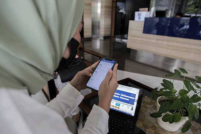 Pekerja kantoran saat membuka aplikasi KAI Access untuk membeli tiket kereta mudik di kawasan Jakarta Pusat, Senin (4/4/2022).