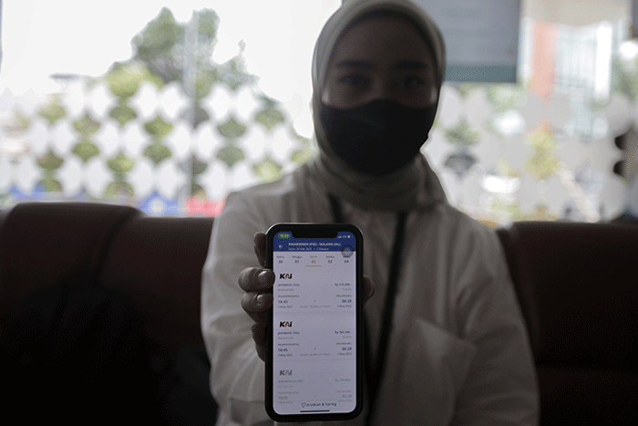 Pekerja kantoran saat membuka aplikasi KAI Access untuk membeli tiket kereta mudik di kawasan Jakarta Pusat, Senin (4/4/2022).