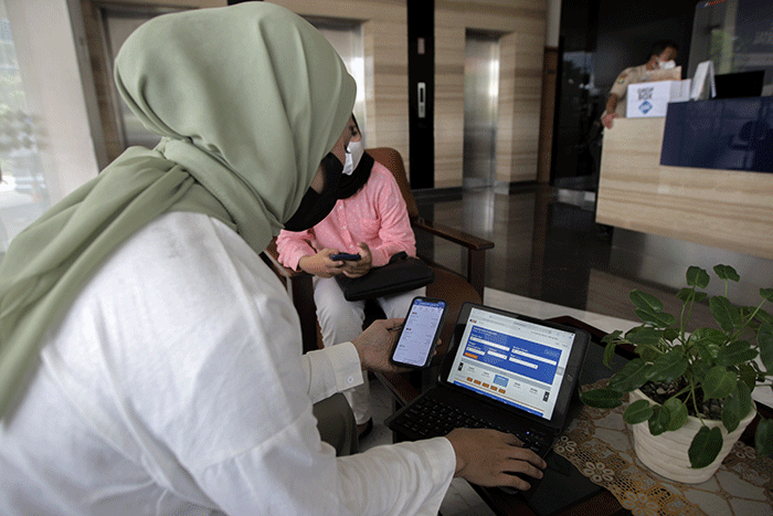 Pekerja kantoran saat membuka aplikasi KAI Access untuk membeli tiket kereta mudik di kawasan Jakarta Pusat, Senin (4/4/2022).