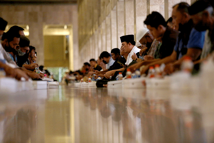 Sejumlah umat Islam bersiap menyantap sajian berbuka puasa di kompleks Masjid Istiqlal, Jakarta, Senin (4/4/2022).
