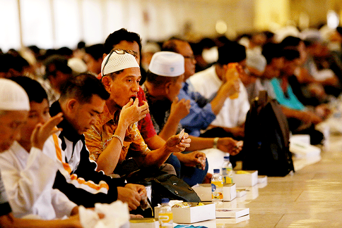 Sejumlah umat Islam bersiap menyantap sajian berbuka puasa di kompleks Masjid Istiqlal, Jakarta, Senin (4/4/2022).