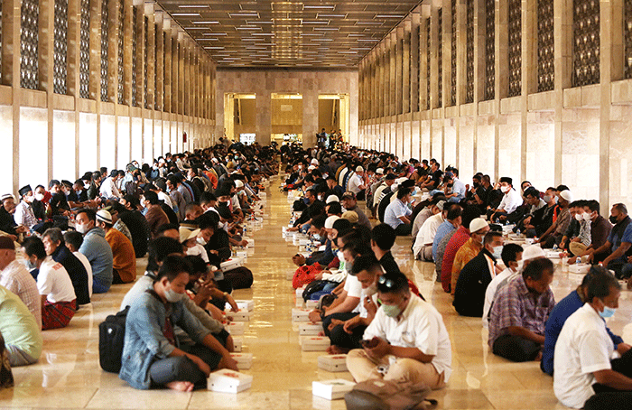 Sejumlah umat Islam bersiap menyantap sajian berbuka puasa di kompleks Masjid Istiqlal, Jakarta, Senin (4/4/2022).