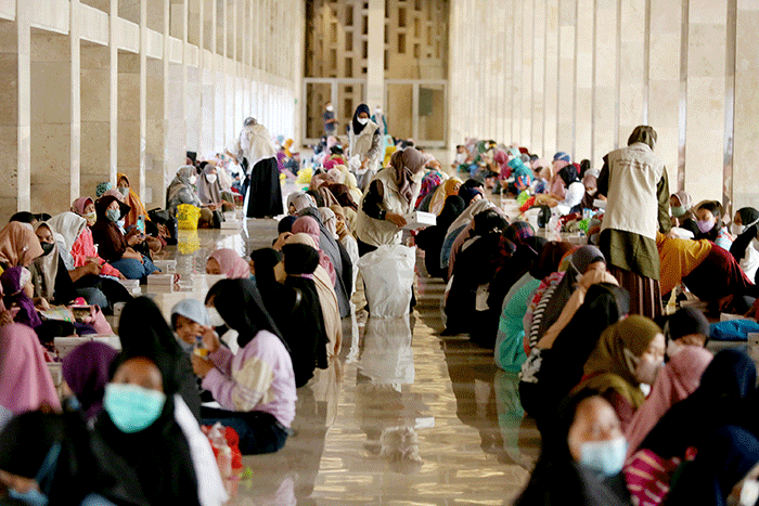 Sejumlah umat Islam bersiap menyantap sajian berbuka puasa di kompleks Masjid Istiqlal, Jakarta, Senin (4/4/2022).