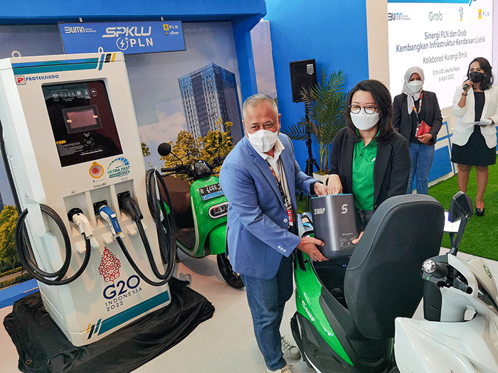 General Manager PLN UID Jakarta Raya, Doddy B. Pangaribuan (kiri) bersama Direktur PT Sepeda Untuk Indonesia Iki Sari Dewi mengganti bateri untuk motor listrik.