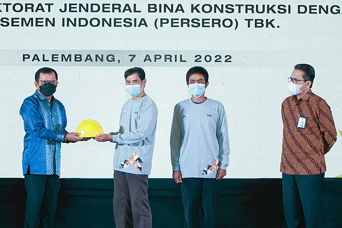 Direktur Utama SIG, Donny Arsal (kiri) menyerahkan Alat Pelindung Diri sebagai tanda dimulainya pelatihan untuk tenaga konstruksi.