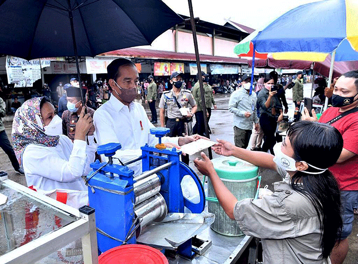 Presiden Joko Widodo didampingi Ibu Negara Iriana Joko Widodo berbincang dengan pedagang makanan saat kunjungan kerja ke Pasar Modern Angso Duo di Jambi.
