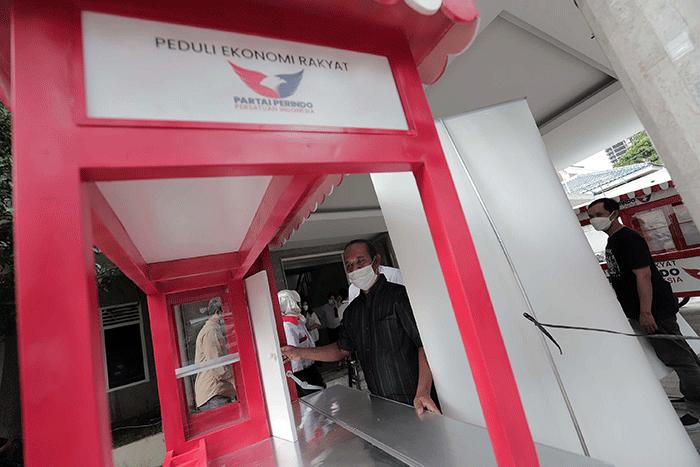 Ketua DPP Partai Perindo Bidang Hukum dan HAM Tama S Langkun menyerahkan bantuan gerobak kepada penerima bantuan pedagang nasi padang dan bakmi ayam.