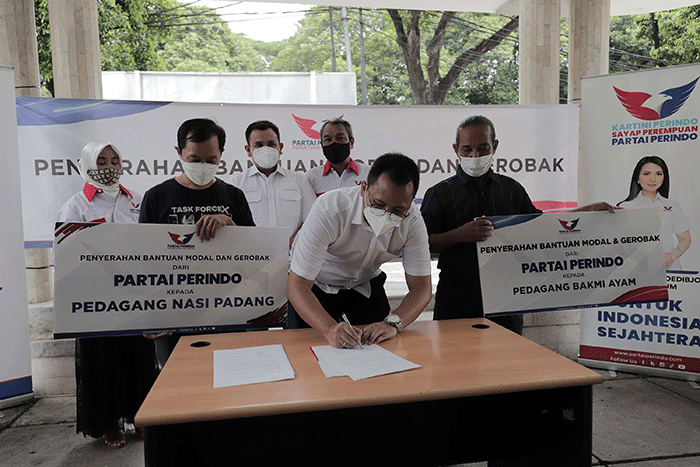 Ketua DPP Partai Perindo Bidang Hukum dan HAM Tama S Langkun menyerahkan bantuan gerobak kepada penerima bantuan pedagang nasi padang dan bakmi ayam.