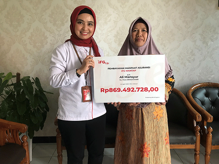 Representative Office Manager Kantor Representatif IFG Life Surabaya, Rina Tania secara simbolis menyerahkan pembayaran polis IFG Mantap kepada Ibu Munawaroh.