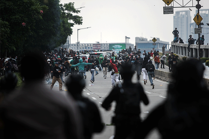 Mahasiswa bentrok dengan aparat kepolisian saat menggelar aksi unjuk rasa didepan Gedung DPR, Jakarta, Senin (11/4/2022).