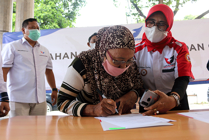 Bantuan gerobak serta modal secara simbolik kepada Ibu Mayem pedagang sayur dan Bapak Rukmanan Pedagang Siomai saat Penyerahan di Kantor DPP Partai Perindo.