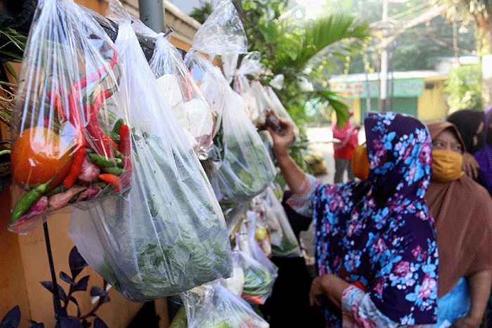 Warga mengambil sayuran, lauk pauk dan baju bekas gratis hasil sumbangan Warga RT 002 RW 04 dan para donatur di Jalan Jati Padang VI, Jakarta.