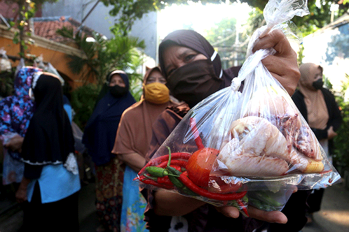 Warga mengambil sayuran, lauk pauk dan baju bekas gratis hasil sumbangan Warga RT 002 RW 04 dan para donatur di Jalan Jati Padang VI, Jakarta.