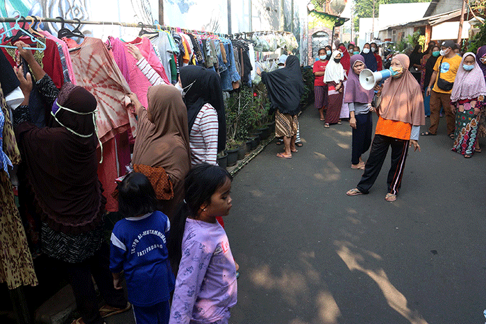 Warga mengambil sayuran, lauk pauk dan baju bekas gratis hasil sumbangan Warga RT 002 RW 04 dan para donatur di Jalan Jati Padang VI, Jakarta.