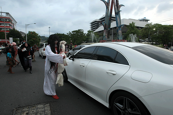 Aksi sekumpulan orang berkostum hantu yang tergabung dalam komunitas Semarangker membagi-bagikan takjil kepada pengguna jalan.