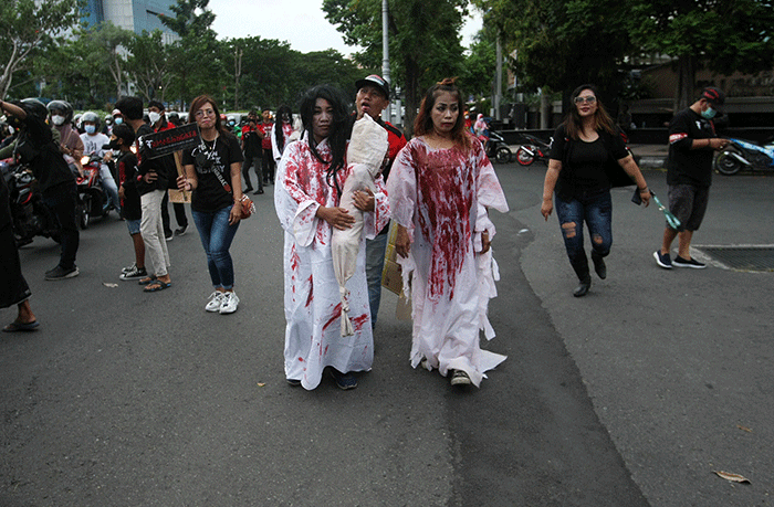 Aksi sekumpulan orang berkostum hantu yang tergabung dalam komunitas Semarangker membagi-bagikan takjil kepada pengguna jalan.