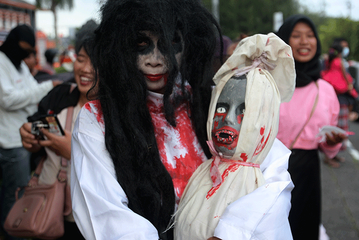 Aksi sekumpulan orang berkostum hantu yang tergabung dalam komunitas Semarangker membagi-bagikan takjil kepada pengguna jalan.