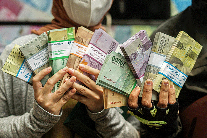 Warga menukarkan uang pecahan kecil di mobil Kas Keliling BI, Pasar Induk Kramat Jati, Jakarta Timur, Selasa (19/4/2022).