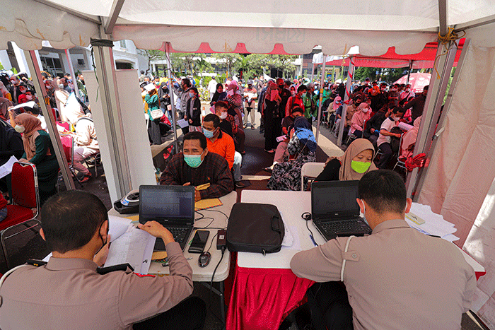 Warga menunjukkan tiket mudik gratis Lebaran 2022 di depan Gedung Balai Pertemuan Metro Jaya, Polda Metro Jaya, Jakarta Selatan, Sabtu (23/4/2022).